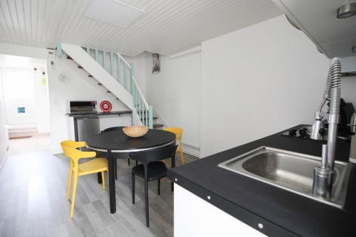 une cuisine avec un évier et une table avec des chaises jaunes dans l'établissement Belle maison à Saint Cybard -Fibre,Jardin,Netflix, à Angoulême