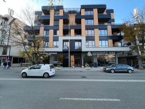 two cars parked in front of a building at Roosevelt Apartment in Skopje