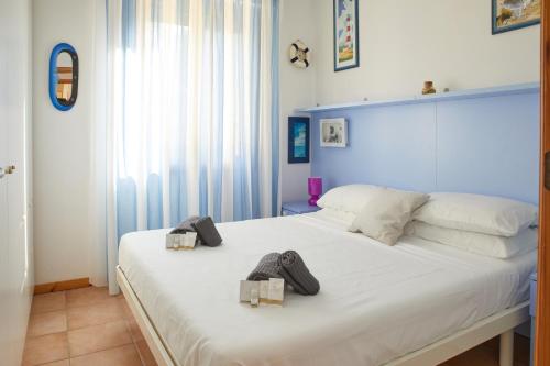 a bedroom with a large white bed with two boxes on it at Conero - Patio Privato e Parcheggio by Host Hero in Marcelli