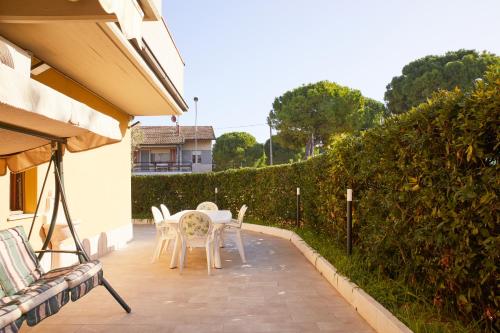 a patio with a table and chairs and a hedge at Conero - Patio Privato e Parcheggio by Host Hero in Marcelli