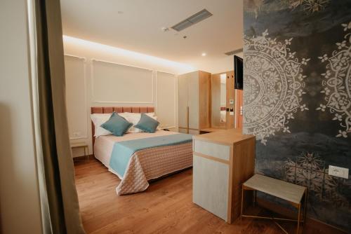 1 dormitorio con 1 cama con almohadas azules en Martiness Hotel Durres en Durrës