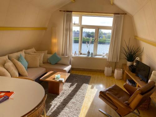 a living room with a couch and a table and a window at Zierikzee Appartement ZZ 41 at the Waterfront in Zierikzee