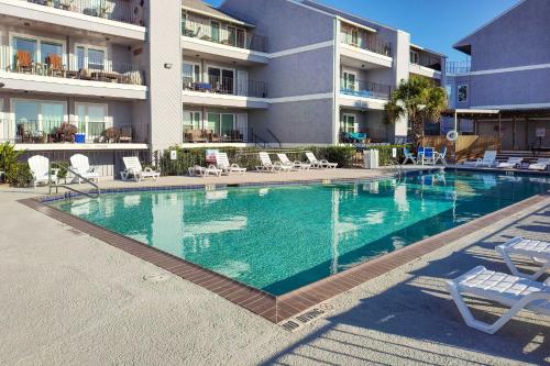 a large swimming pool in front of a building at Gulf Views and Resort Perks Walkable Galveston Gem in Galveston