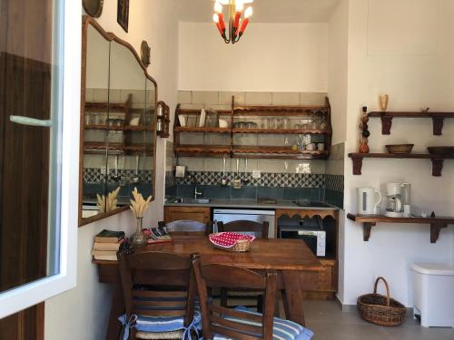 a kitchen with a wooden table with chairs and a counter at Del & Sol in Skopelos Town