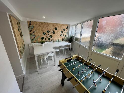 a room with a ping pong table and a dining room at Sunnyside Aparthotel Tropical suite, 10 min from Blackpool tower, outside space, free parking in Blackpool