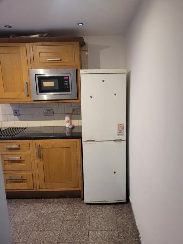 a kitchen with a white refrigerator and a microwave at NO 7 Decent Home (Generous luxury bedroom) in Ashton under Lyne