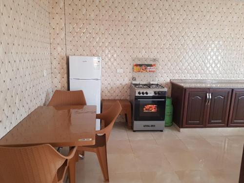 una pequeña cocina con fogones y nevera. en Ibbin hospitality house, en Ajloun
