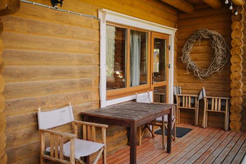 a wooden table and chairs on the porch of a cabin at Vidal in Tatariv