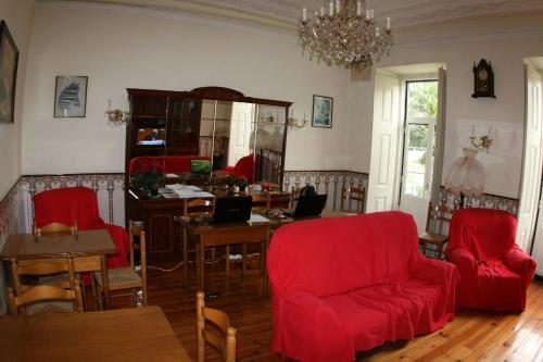 a living room with red chairs and a desk with a laptop at Mana Guest House in Lisbon