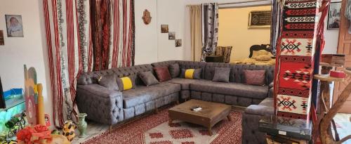 a living room with a couch and a mirror at Villa Atlas Oasis in Shabīkah