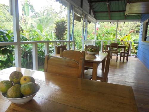 a dining room with a table and a bowl of fruit at Hotel Casitas Mar y Luz in Puerto Viejo