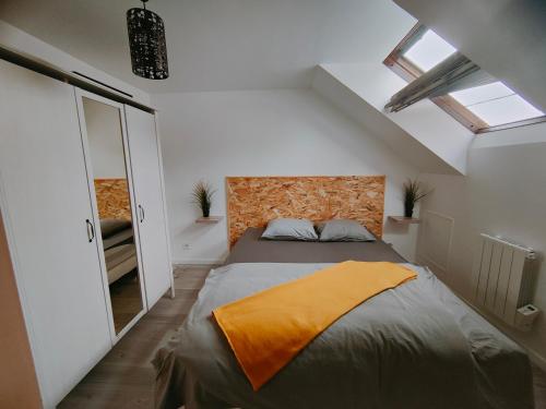 - une chambre avec un grand lit et une couverture orange dans l'établissement Les Lofts De Provins: Apt 7, à Provins