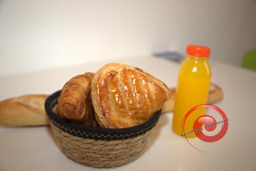 a basket of croissants and a bottle of orange juice at Les Lofts De Provins: Apt 7 in Provins