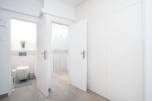 a white bathroom with a shower and a toilet at Bright Apartment in Old Town by Prague Days in Prague