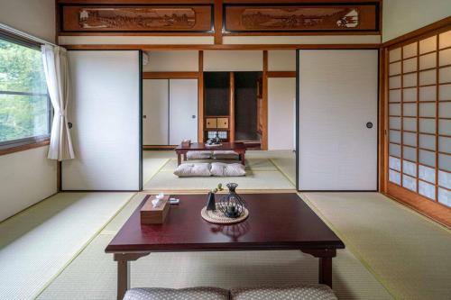 a room with a table and a bed in a room at 自然豊か棚田百選の棚田・道の駅・金剛山登山・釣り・ゴルフに便利/8名宿泊可広々一軒家/無料駐車場 in Tondabayashi