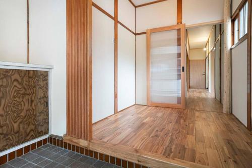 an empty hallway with wood floors and a door at 自然豊か棚田百選の棚田・道の駅・金剛山登山・釣り・ゴルフに便利/8名宿泊可広々一軒家/無料駐車場 in Tondabayashi