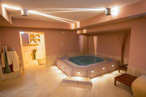 eine große Whirlpool-Badewanne in der Mitte eines Zimmers in der Unterkunft Style Hotel Grifone in Madonna di Campiglio