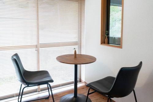 a table and chairs in a room with a window at 自然豊か棚田百選の棚田・道の駅・金剛山登山・釣り・ゴルフに便利/8名宿泊可広々一軒家/無料駐車場 in Tondabayashi