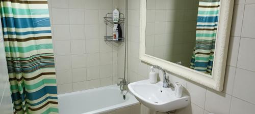 W łazience znajduje się umywalka, lustro i wanna. w obiekcie Next to the marina w mieście Aszkelon