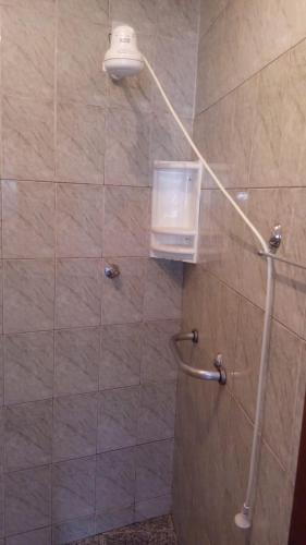 a bathroom with a shower with a glass door at Raízes de Afrodite Kitnet in São Thomé das Letras