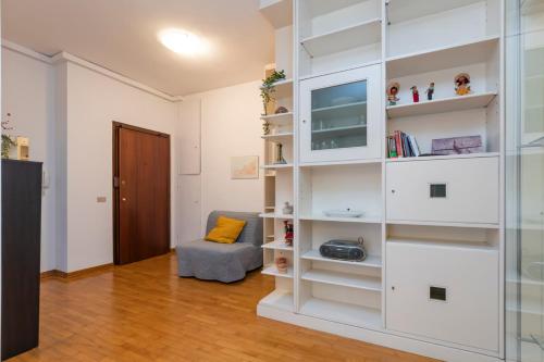 [Mimmi Apartment] Zurigo 12 في ميلانو: غرفة معيشة مع رفوف بيضاء وتلفزيون