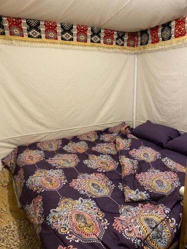 um edredão numa cama numa tenda em Muhra em Siwa
