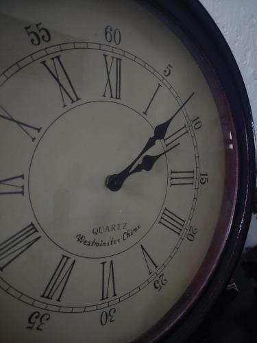a clock with roman numerals on it at Casa Yoly Hostel Granada in Granada