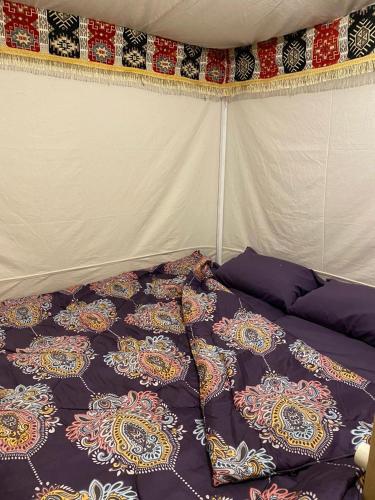 Una cama en una tienda con almohadas. en Muhra, en Siwa