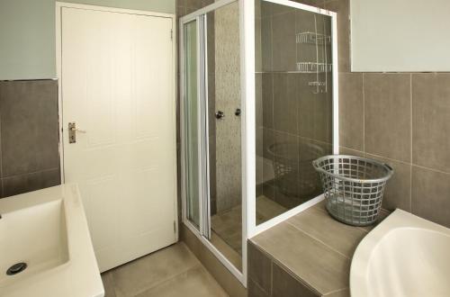 W łazience znajduje się prysznic, umywalka i toaleta. w obiekcie Bella Casa w mieście Langebaan