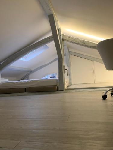 une pièce vide avec un lit et une chaise dans l'établissement Studio type loft, à Paris