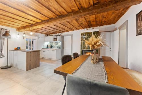 a kitchen and dining room with a wooden table and chairs at Chalupa u Břízek in Hennersdorf