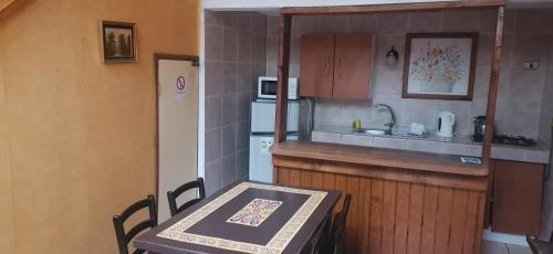 a small kitchen with a table and a refrigerator at Cabañas Hosteria de Vilches in Vilches