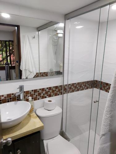 y baño con ducha, aseo y lavamanos. en Apartaestudio Laureles - Viva Laureles, en Medellín
