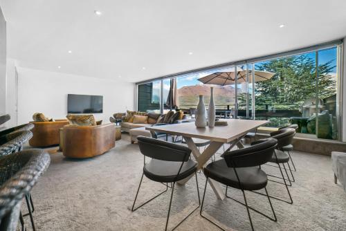una sala de estar con una mesa y sillas en Luxury Penthouse P2, en Queenstown