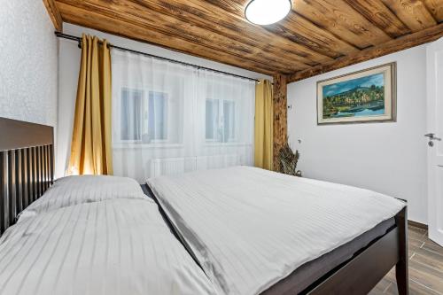 1 cama grande en un dormitorio con ventana en Chalupa u Břízek, en Dolní Branná