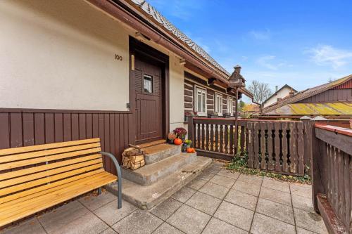 a wooden bench sitting outside of a house at Chalupa u Břízek in Hennersdorf