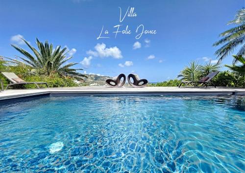 a swimming pool with a pair of scissors in the water at Villa la Folie Douce, luxury and serenity, Orient Bay in Orient Bay