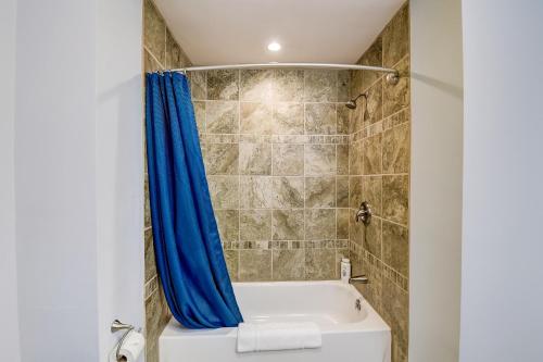 a bathroom with a bath tub with a blue shower curtain at WFC Lakefront Views Family or Romance in Wisconsin Dells