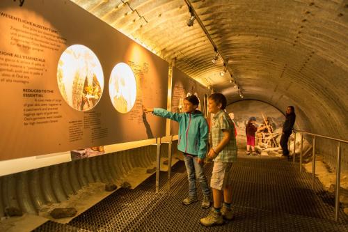 two people standing in a tunnel looking at a exhibit at Glacier Hotel Grawand in Maso Corto