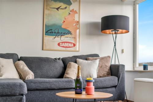 a living room with a couch and a bottle on a table at Duinenhuisje in Ostend