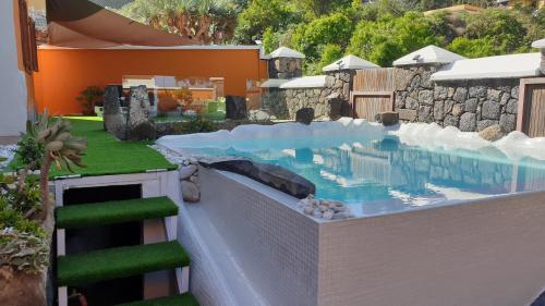 a swimming pool in a yard next to a house at El Pinar in Icod de los Vinos