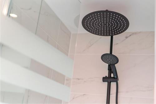 a shower with a shower head in a bathroom at Duinenhuisje in Ostend