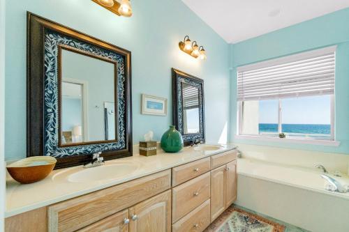 een badkamer met een spiegel, een bad en een wastafel bij Turtle Ridge in Pensacola Beach