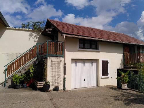 ein weißes Haus mit einer Garage und einer Treppe in der Unterkunft Relais des Combettes in Sutrieu