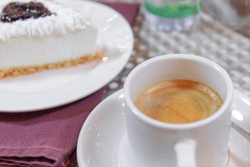 a cup of coffee and a piece of cake on a table at Petra Elite Hotel in Wadi Musa
