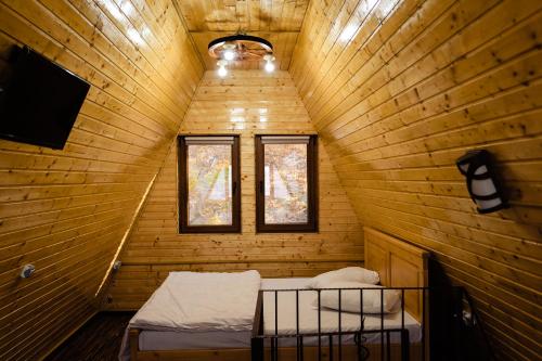 a room with two beds in a wooden cabin at La Maria si Ioana in Curtea de Argeş