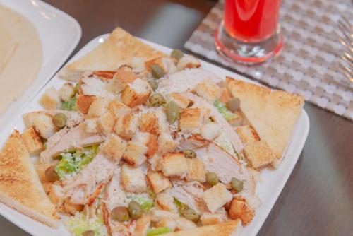 a plate of food with meat and vegetables on a table at Petra Elite Hotel in Wadi Musa