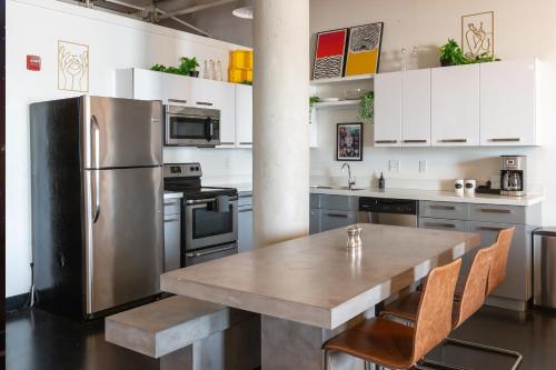 a kitchen with a table and a stainless steel refrigerator at Hotel Clemons in Chattanooga