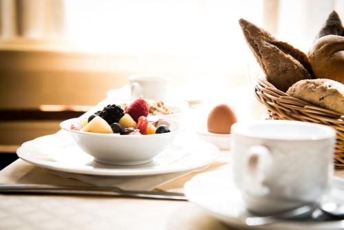 a table with plates of food and a basket of bread at Hampshire Hotel – Voncken Valkenburg in Valkenburg