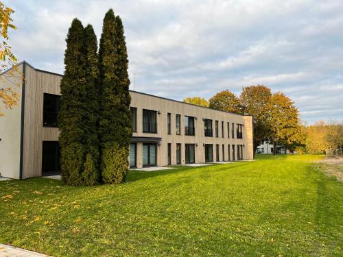 an office building with two trees in front of it at Albatross Beach Apartment - SPA, Sea and Forest in Ķesterciems